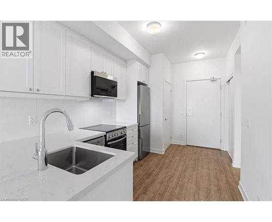 A kitchen with white cabinets and a stainless steel sink.