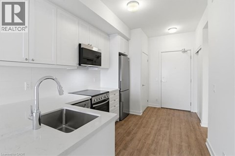 A kitchen with white cabinets and a stainless steel sink.