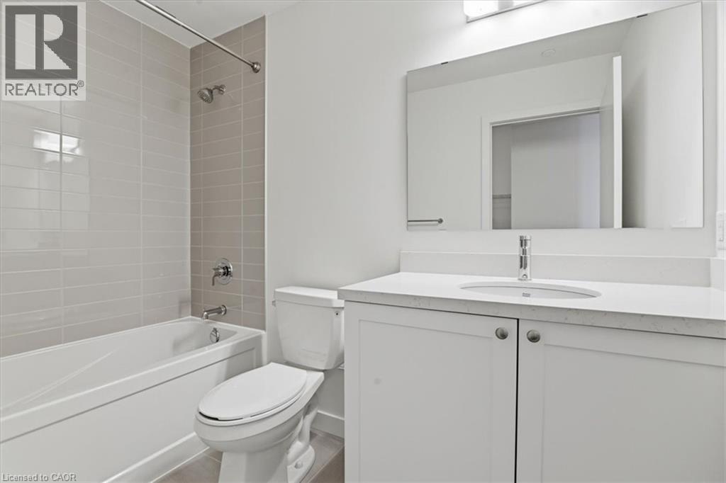 A white bathroom with a toilet, sink, and bathtub.