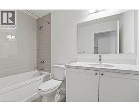 A white bathroom with a toilet, sink, and bathtub.