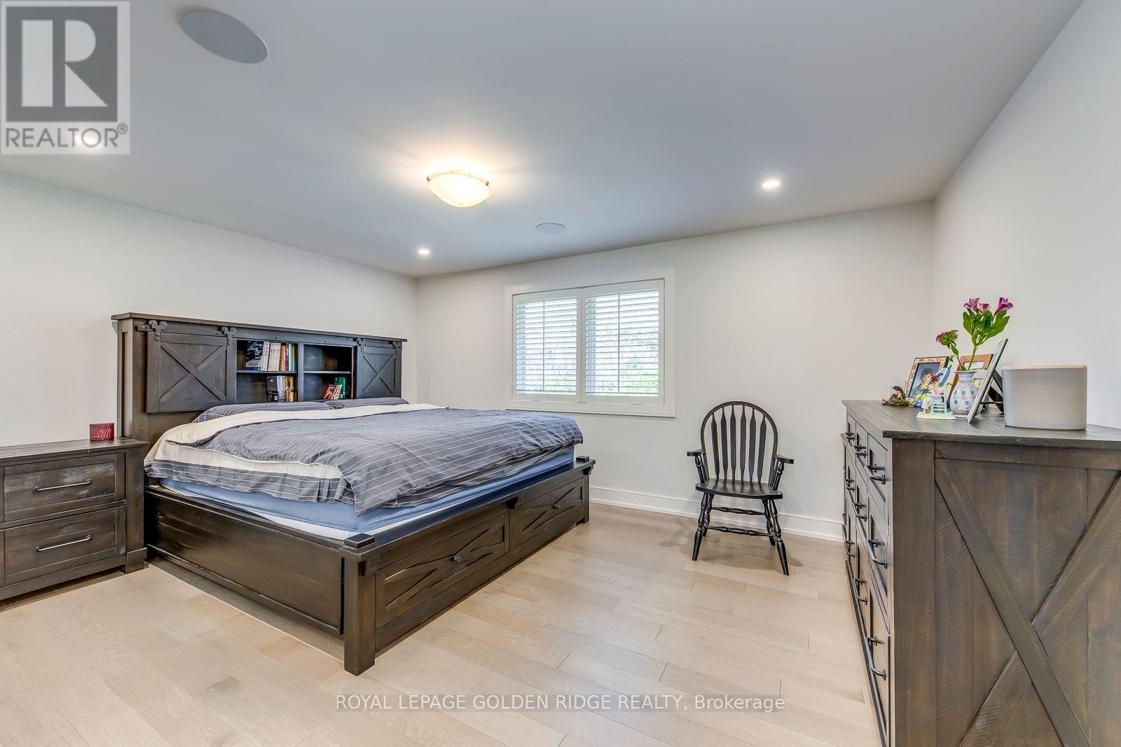 A bedroom with a bed, chair, and desk.