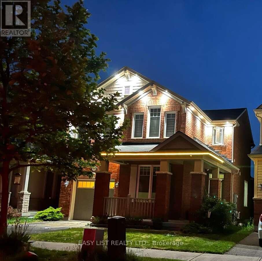 A house with a lit up front porch and a tree in front of it.