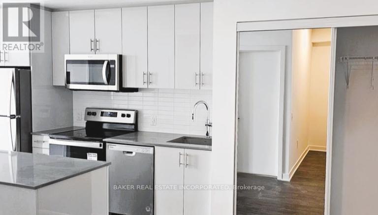 A modern kitchen with a stainless steel refrigerator, microwave, and oven.