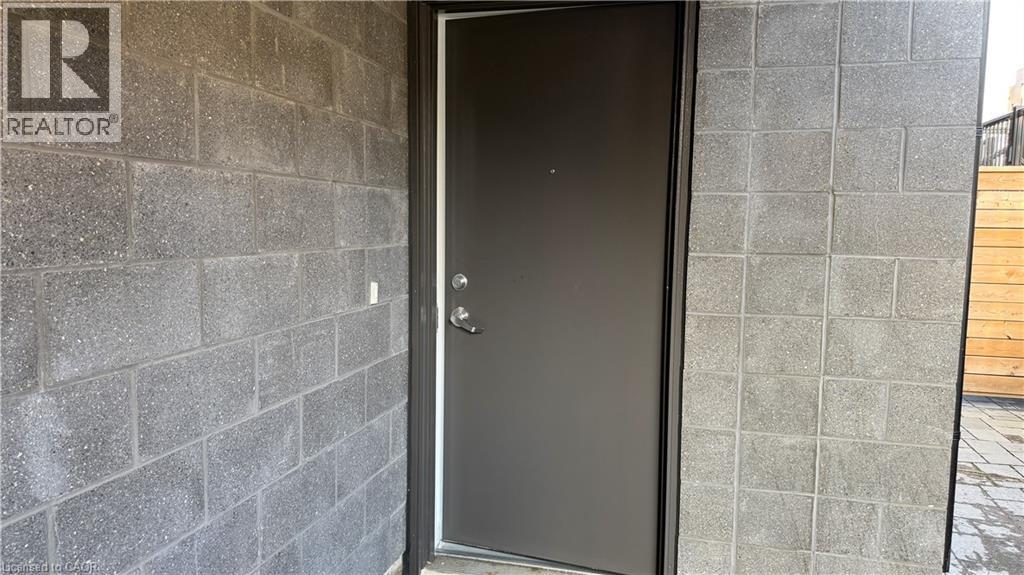 A door with a glass panel is set in a brick wall.