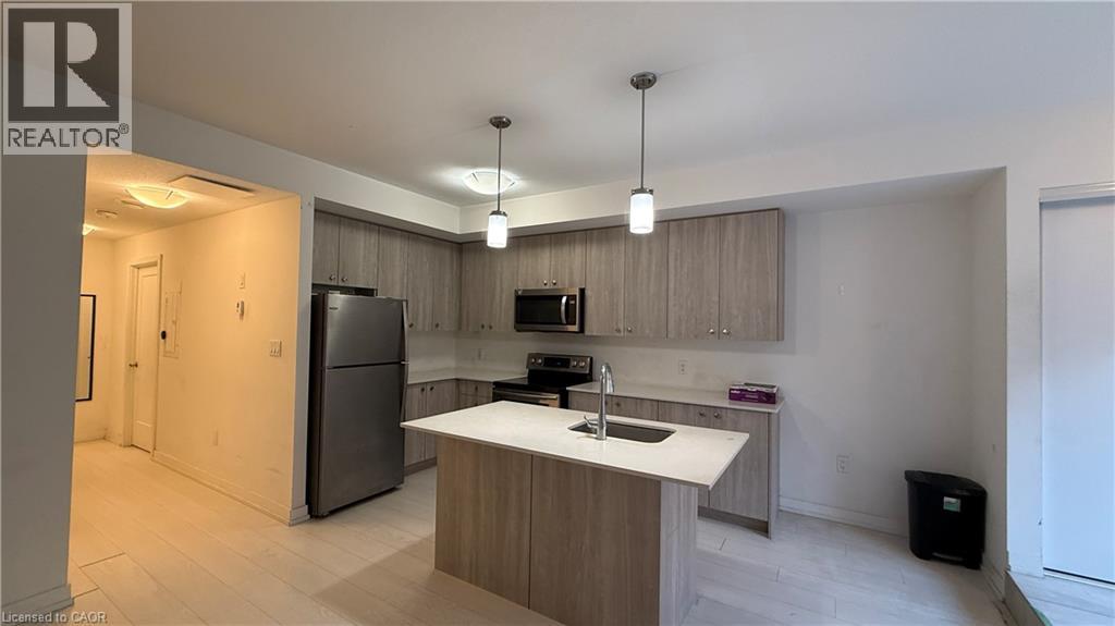 A modern kitchen with a refrigerator, sink, and cabinets.