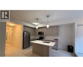 A modern kitchen with a refrigerator, sink, and cabinets.