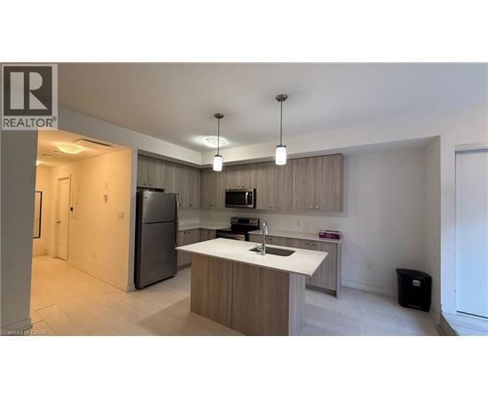 A modern kitchen with a refrigerator, sink, and cabinets.