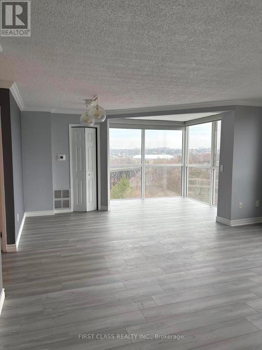 A room with wooden flooring and a large window with a view of the outdoors.
