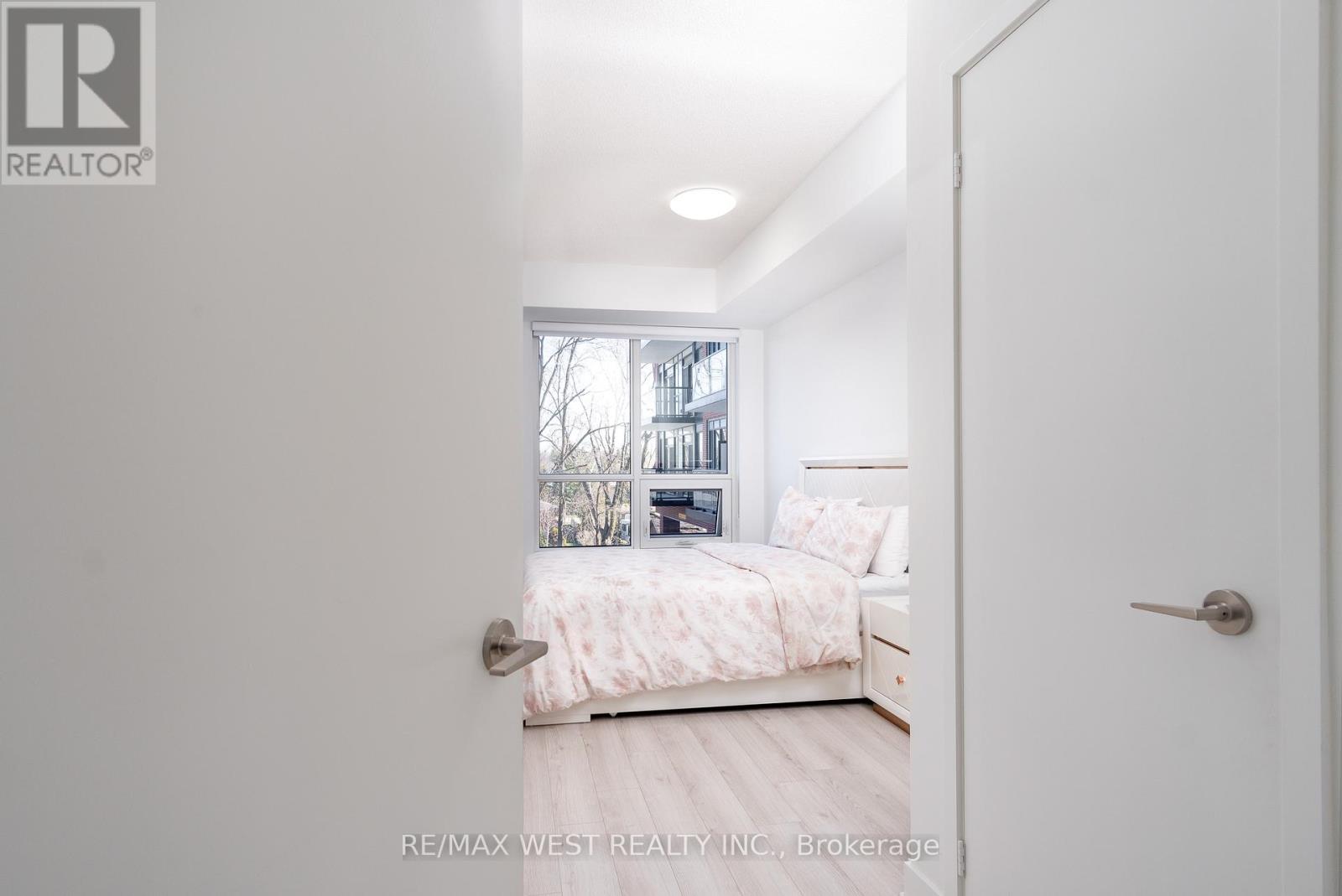 A bedroom with a bed, nightstand, and window.