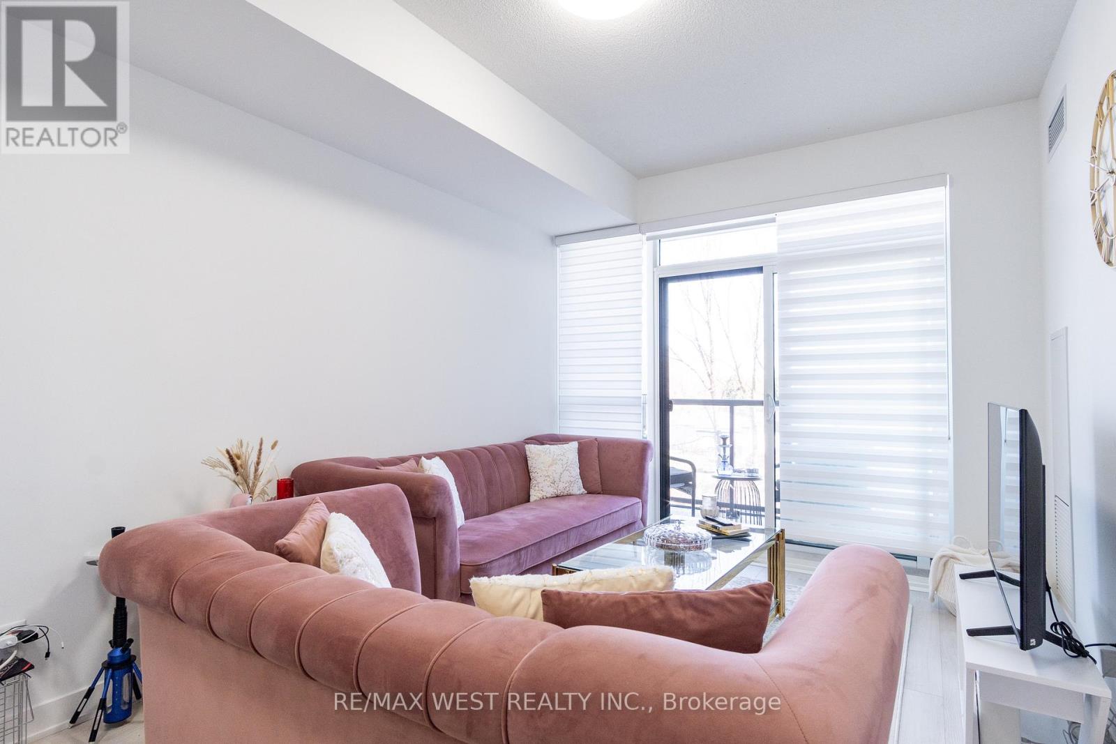 A living room with a pink couch and a flat screen TV.