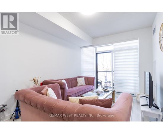 A living room with a pink couch and a flat screen TV.