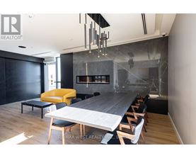 A modern dining room with a long table and chairs.