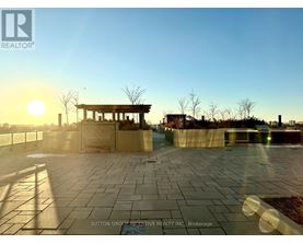 A sunset view of a paved area with a gazebo in the distance.