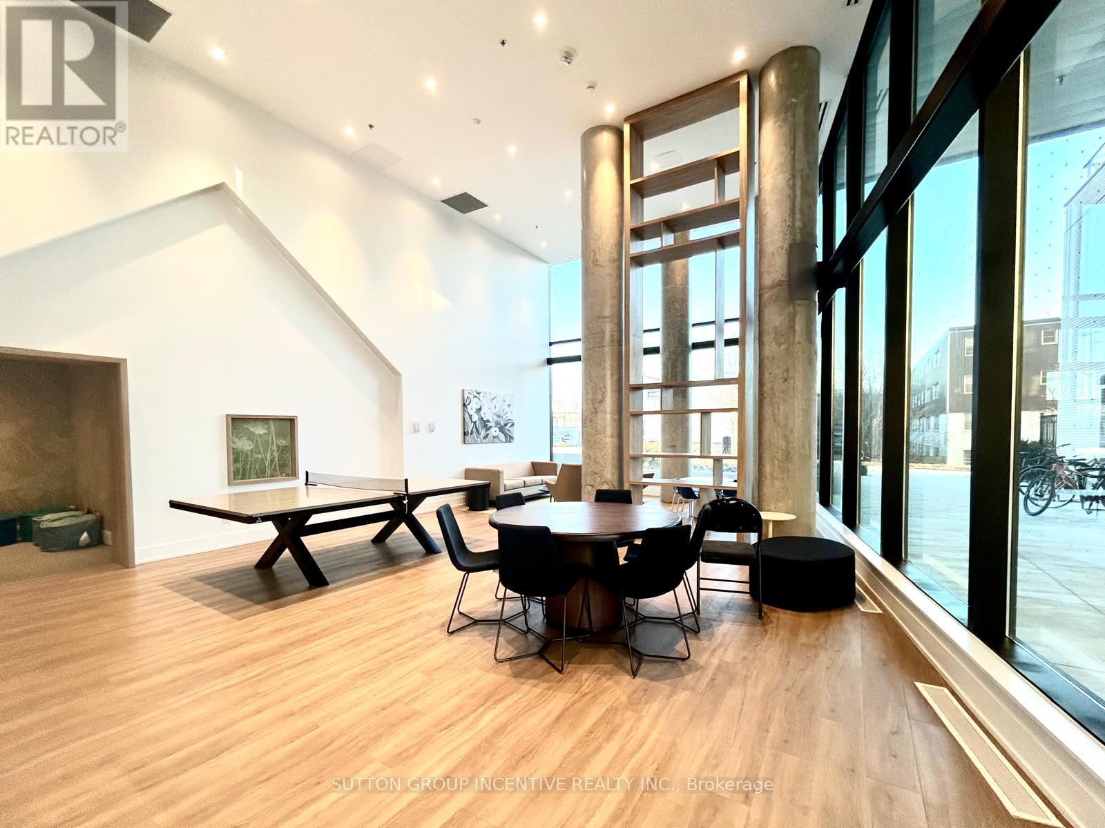 A modern dining room with a wooden floor and a large table with chairs.