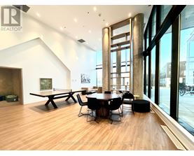 A modern dining room with a wooden floor and a large table with chairs.