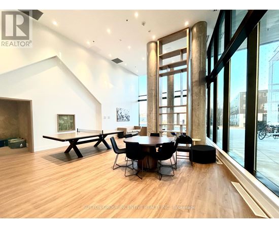 A modern dining room with a wooden floor and a large table with chairs.