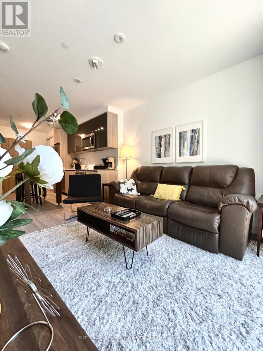 A living room with a brown leather couch and a coffee table.