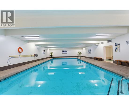 A swimming pool inside a building with a logo on the wall.