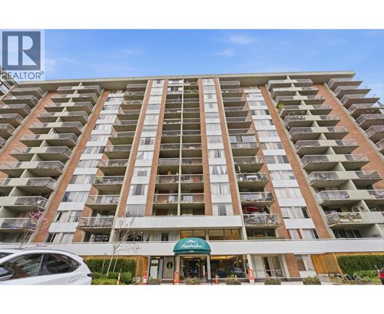 A tall apartment building with a green awning in front.