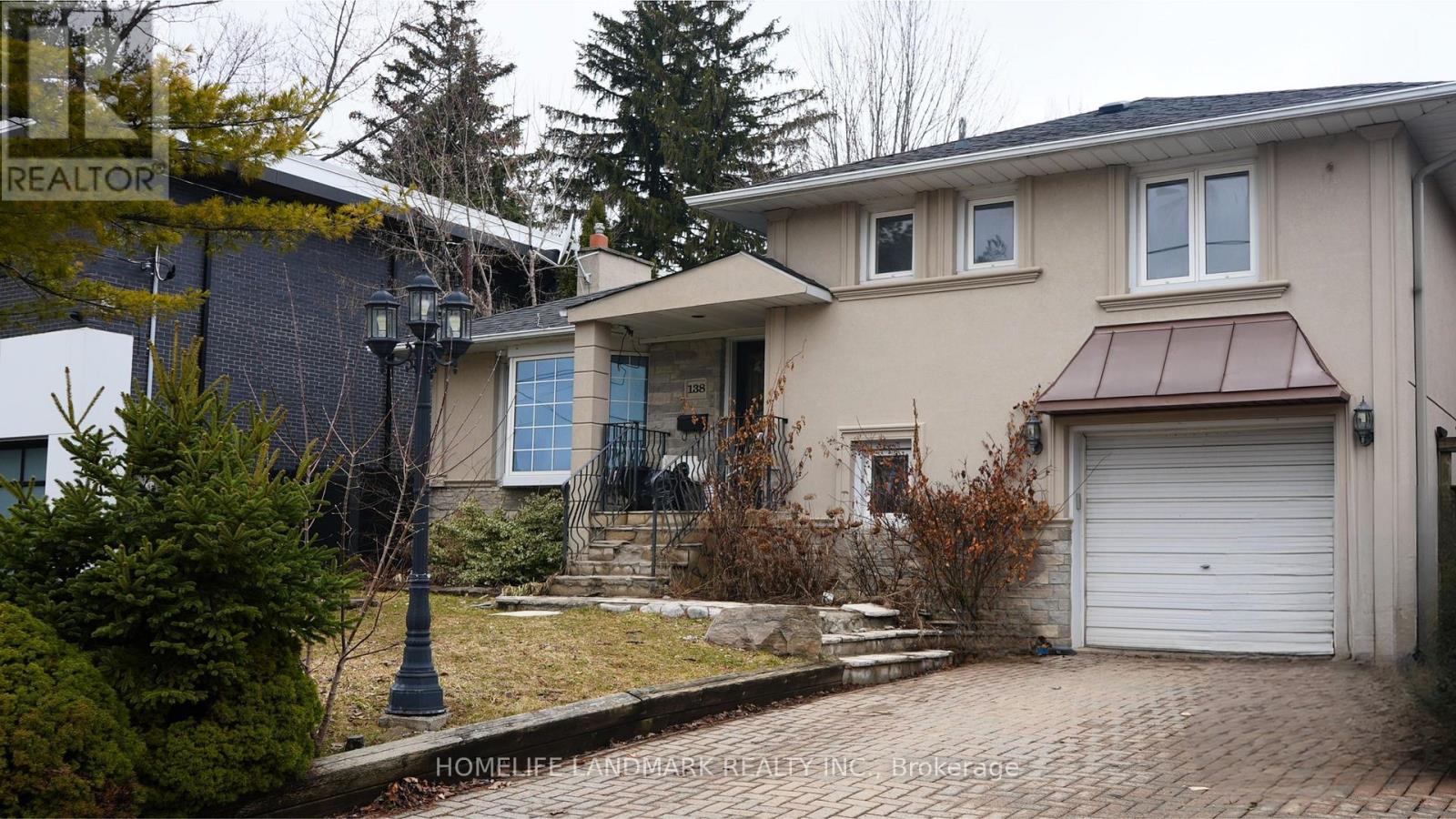 A house with a garage and a driveway in front of it.