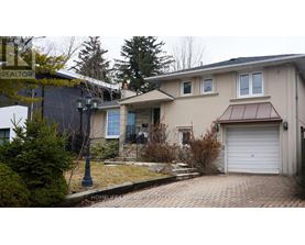 A house with a garage and a driveway in front of it.