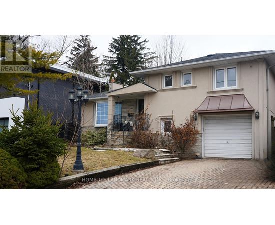 A house with a garage and a driveway in front of it.