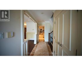 A hallway with a carpeted floor and white walls.