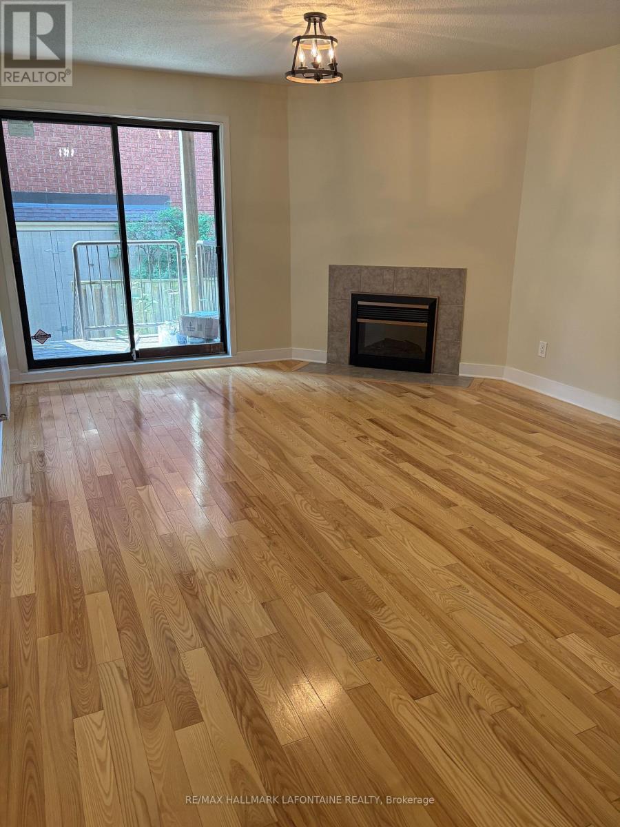 A room with a fireplace and wood flooring.
