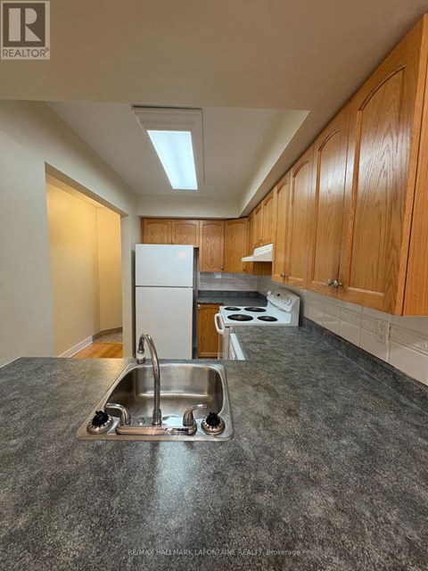 A kitchen with a sink and a refrigerator.