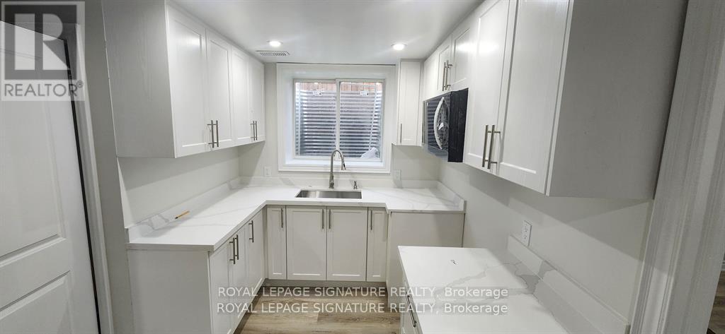 A white kitchen with a sink and cabinets.