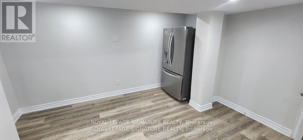 A room with a wooden floor and a Royal LePage Signature Realty Brokerage logo.