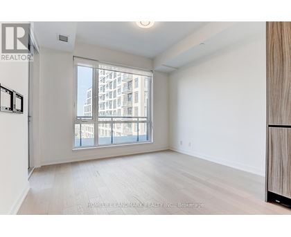 A spacious room with a large window overlooking a cityscape.