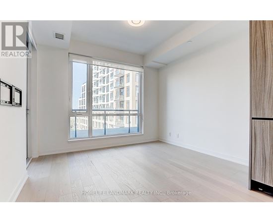 A spacious room with a large window overlooking a cityscape.
