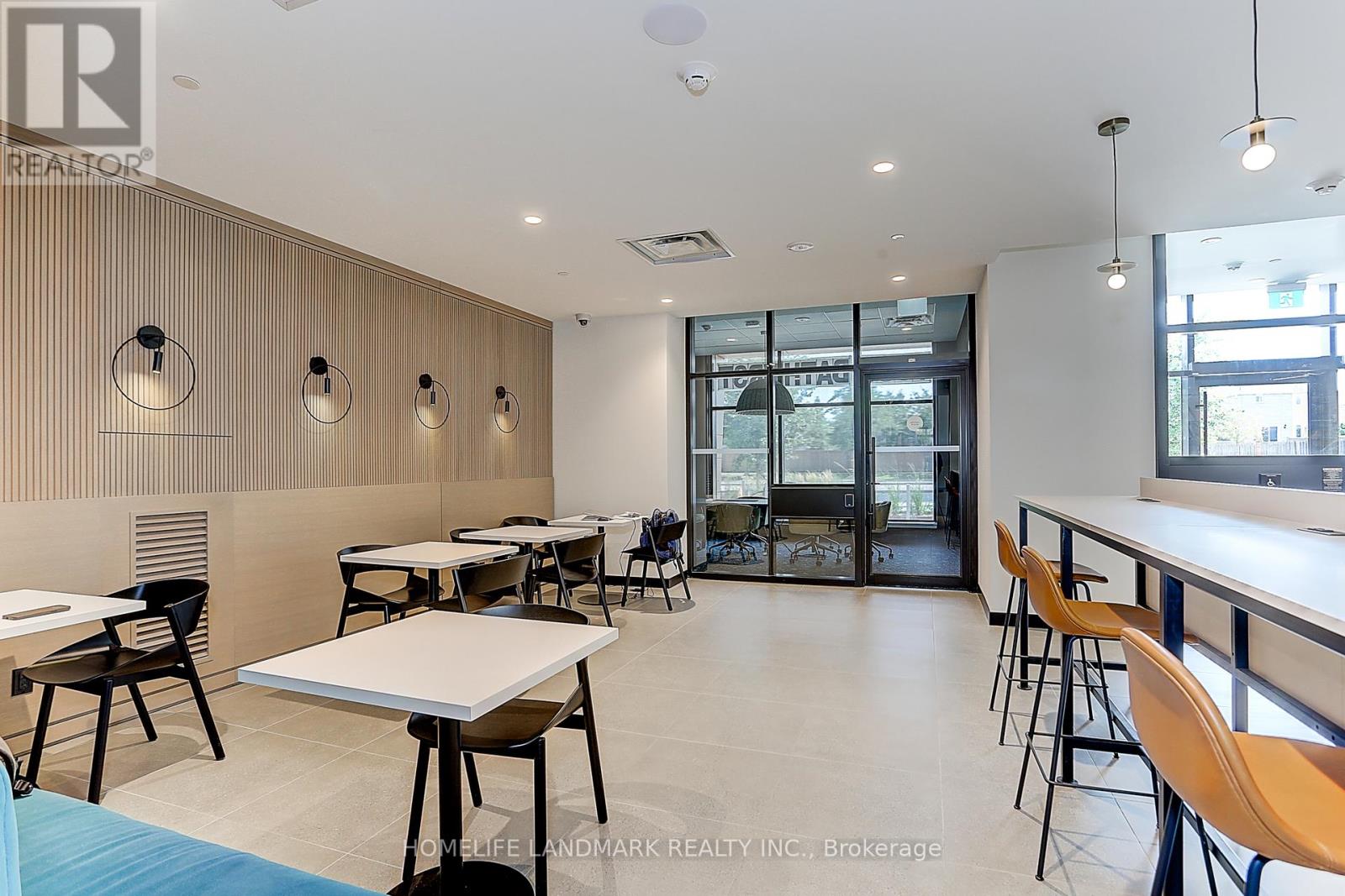 A modern dining area with wooden walls and tables with chairs.