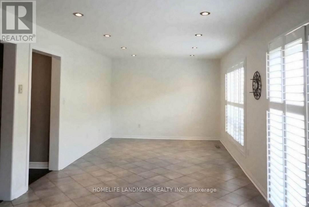 A room with a clock on the wall and a door on the left.