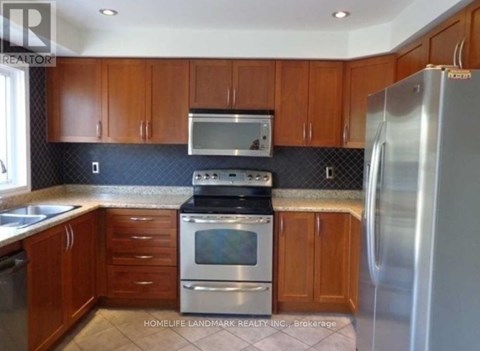 A kitchen with wooden cabinets and a stainless steel refrigerator.