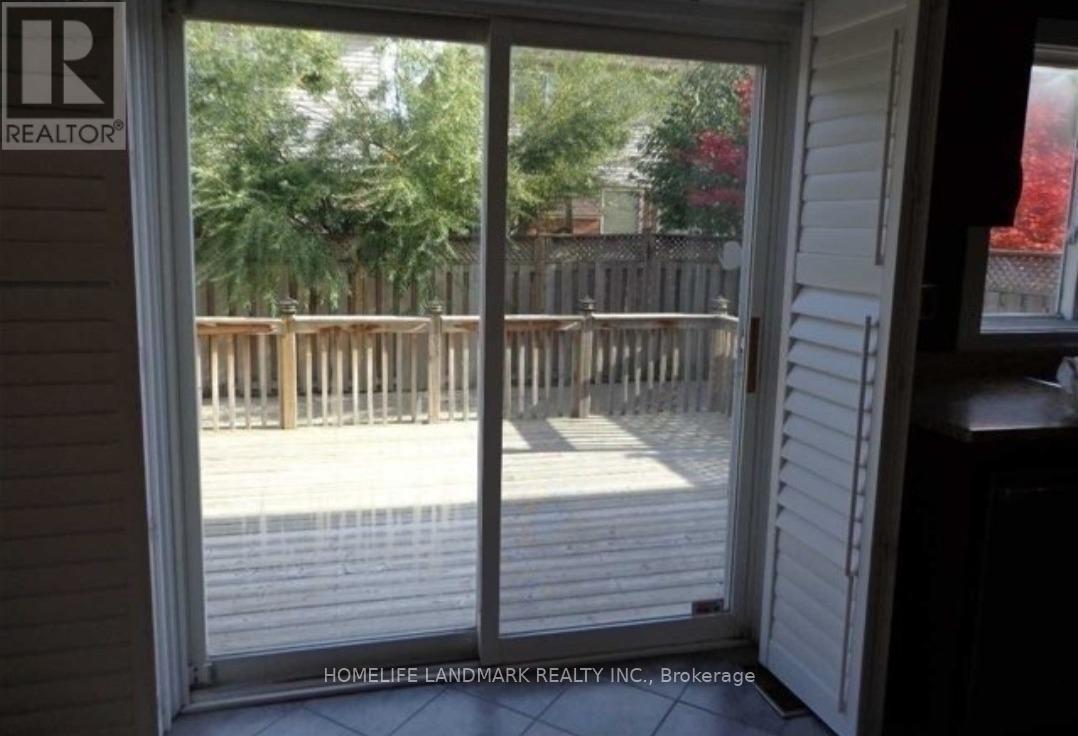 A sliding glass door with a view of a deck and trees.