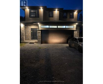 A house with a garage and a car parked in front.