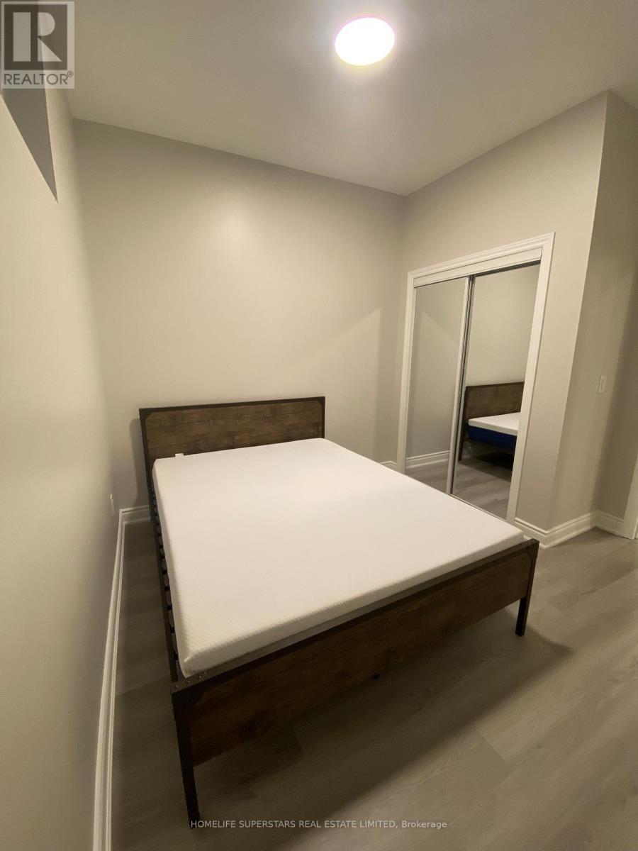 A bedroom with a bed, wooden headboard, and a mirror.