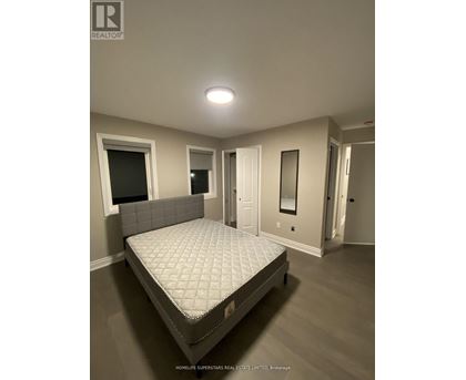 A bedroom with a bed, wooden headboard, and a mirror.