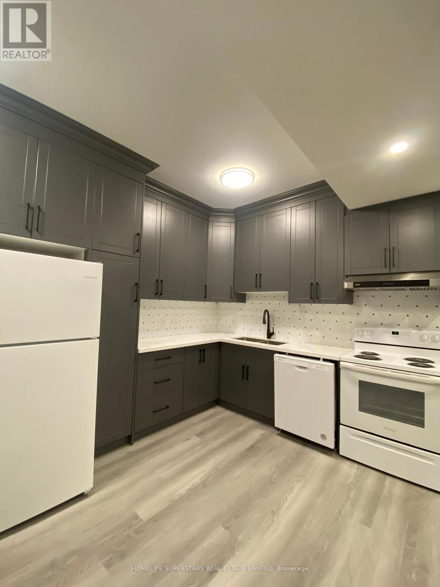 A modern kitchen with white appliances and wooden floors.