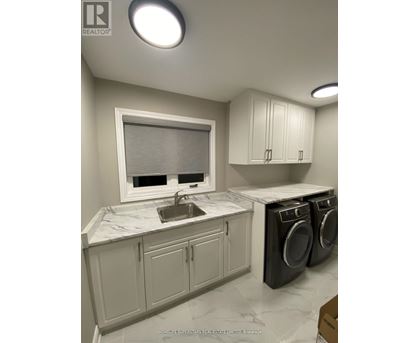 A modern kitchen with white appliances and wooden floors.