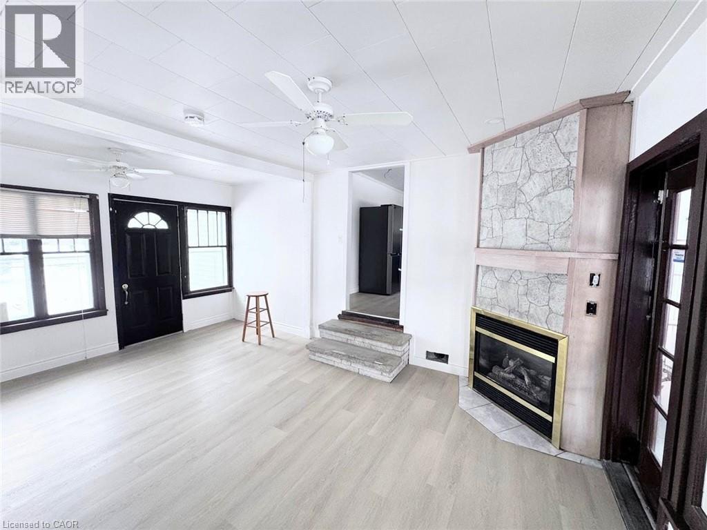 A spacious living room with a fireplace and a bar stool.