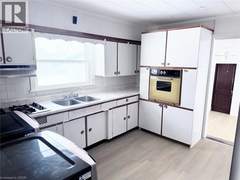 A kitchen with white cabinets and a black stove top oven.