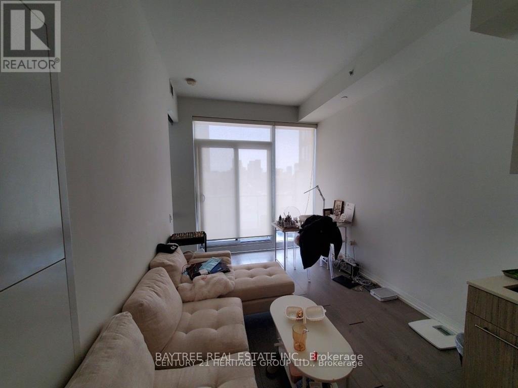 A living room with a couch, a table, and a window.