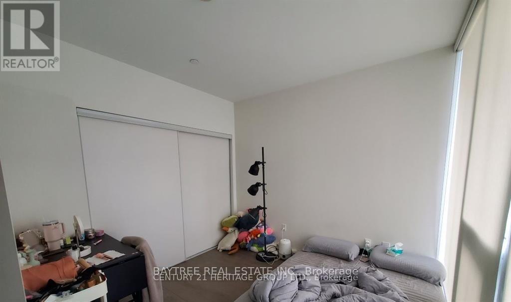 A bedroom with a bed, desk, and chair.