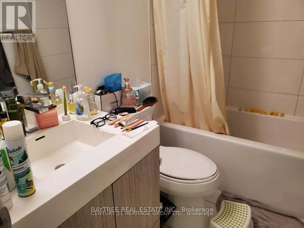 A bathroom with a white toilet, sink, and bathtub.