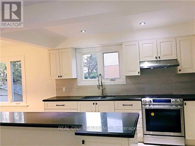 A kitchen with black countertops and white cabinets.