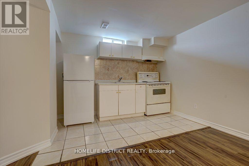A kitchen with white cabinets and a wooden floor.