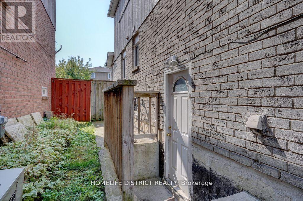 A realtor brokerage sign is on a brick wall.